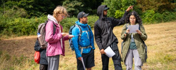 A group of young people talking together and looking at a map